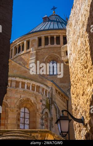 Alte Kalksteinmauern und Straßenlaterne in Jerusalems Altstadt mit historischer Kirchenkuppel im Hintergrund. Stockfoto