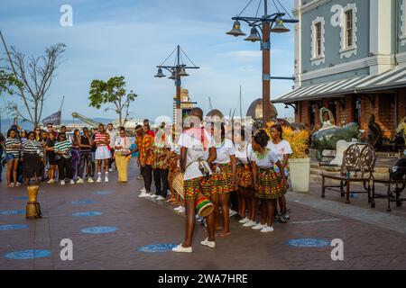 Kinder in traditioneller Zulu-Kleidung tanzen und spielen auf den Straßen von Kapstadt, Südafrika Stockfoto