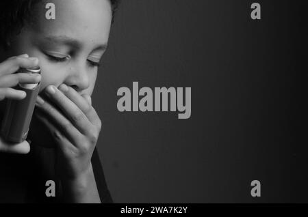 Kind mit Grippe mit Inhalator Atemschutz auf grauem Hintergrund mit Menschen Stockfoto Stockfoto