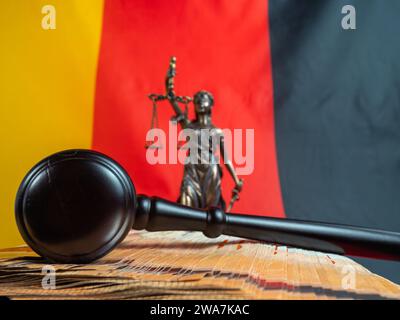 Der Hammer des Richters liegt auf 50-Euro-Scheinen vor dem Hintergrund der deutschen Flagge. Recht und Gerechtigkeit. Stockfoto