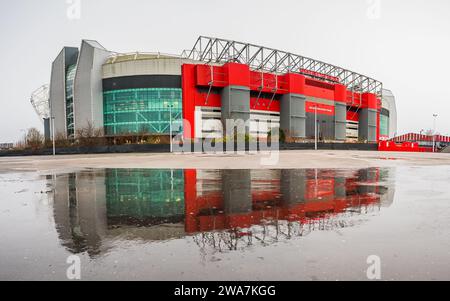 Ein Multi-Bild-Panorama des Old Trafford Stadions, Heimstadion des Manchester United Football Club, spiegelt sich am 2. Januar 2024 in einer großen Pfütze wider. Stockfoto
