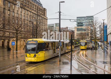 Am 2. Januar 2024 fahren Straßenbahnpaar im Regen an der Station St. Peters Square des Manchester Metrolink-Verkehrsnetzes. Stockfoto