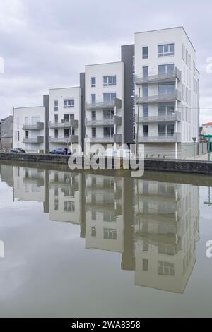 Nancy, Frankreich - Schwerpunkt auf einem modernen Wohnkomplex mit Reflexionen auf Wasser in einem Kanal. Stockfoto