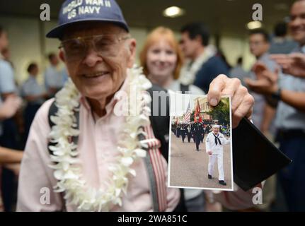 US-Streitkräfte. 161203XD768-017 HONOLULU (3. Dezember 2016) Ein Veteran der US-Navy aus dem Zweiten Weltkrieg zeigt mehreren Militärmitgliedern und Mitarbeitern ein Foto von sich selbst nach der Ankunft eines American Airline-Fluges von Los Angeles auf dem Honolulu International Airport. Mehr als 100 Veteranen des Zweiten Weltkriegs, darunter Überlebende von Pearl Harbor, kamen nach Honolulu, um an den Gedenkveranstaltungen während der Woche teilzunehmen, um den Mut und die Opfer derer zu ehren, die am 7. Dezember 1941 und im gesamten Pacific Theater dienten. Am 7. Dezember 2016 jährt sich der 75. Jahrestag der Angriffe auf Pearl Stockfoto