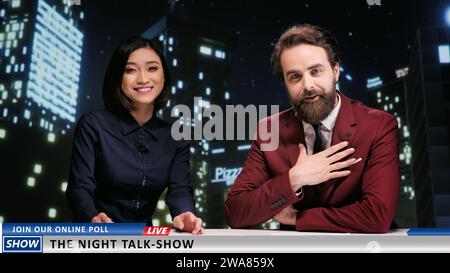 Night Talk Show moderiert im Live-Fernsehen Nachrichten über berühmte Berühmtheiten, die im Bereich Medienunterhaltung arbeiten. Ein vielfältiges Team von Newscastern, die weltweite Themen abdecken. Stockfoto