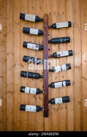 Evora, Alentejo, Portugal. November 2022. Ausstellung von Alentejo-Weinflaschen auf Wandregal in einem rustikalen Restaurant. Stockfoto