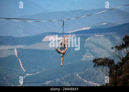 Slacklining über die australischen Alpen. Ein Slackliner, der hoch ausbalanciert am Mount Buffalo in Victoria, Australien. Stockfoto