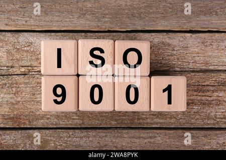 Internationale Organisation für Normung. Würfel mit der Abkürzung ISO 9001 auf Holztisch, Draufsicht Stockfoto