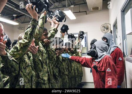 US-Streitkräfte. REAT LAKES, Illinois (10. Januar 2018) Rekruten rezitieren ihre Namen und Divisionsnummern, während sie die Wirkung von Tränengas in der Vertrauenskammer der USS Chief Training Facility beim Recruit Training Command (RTC) erleben. Rekruten üben CBR-D durch praxisnahes Lernen aus, was bedeutet, dass Rekruten „trainieren, wie wir kämpfen“. Die Experten des USS Chief verbringen mehrere Tage damit, Rekruten zu Schulen, die von grundlegender Schadensbegrenzungsausrüstung bis hin zu fortgeschrittenen Feuerbekämpfungstechniken an Bord reichen. Etwa 30.000 bis 40.000 Rekruten absolvieren jährlich nur die Marine Stockfoto