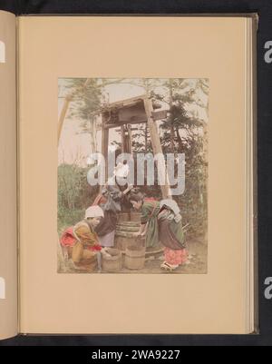 Drei Frauen waschen Reis mit einem Brunnen, ca. 1887 - in oder vor 1897 Foto Japan Fotomaterial Albumen drucken gut. Getreide, Getreide, Mais (Gras mit Körnern, angebaut für Lebensmittel, z. B.: Weizen, Reis, Roggen, Hafer, Mais, Buchweizen, Hirse). Holzbehälter: Fass, Fass, Eimer Stockfoto