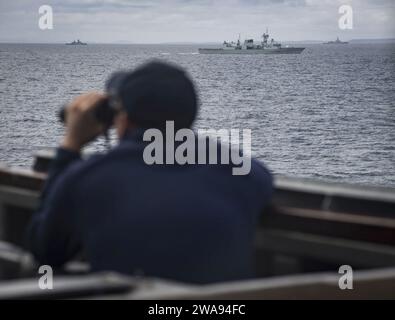 US-Streitkräfte. 180426RG482-118 THE MINCH (26. April 2018) Fähnrich John Nothacker verwendet ein Fernglas, um die Entfernung der kanadischen Fregatte HMCS St. zu messen John's (340), links, die deutsche Braunschweiger Klasse Korvette FGS Erfurt ( F 262), Mitte und die spanische Alvaro de Bazan-Klasse-Lenkraketenfregatte SPS Mendez Nunez (F 104), die neben dem Arleigh Burke-Klasse-Lenkraketenzerstörer USS Ross (DDG 71) während der Übung Joint Warrior 18-1 am 26. April 2018 dampfte. Gemeinsame, von Warriorisa UK geführte multinationale Übung, die Interoperabilität und Zusammenarbeit in allen anwendbaren Kriegsgebieten ausübt Stockfoto