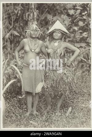 Porträt von zwei unbekannten jungen Frauen auf Pagai in der Gestation der Insel, 1891 - 1912 Foto zwei junge Frauen auf Pagai in der Gestation der Insel. Das rechte Mädchen trägt einen Korbrock und das linke trägt ein Tuch um die Taille. Auf dem Kopf tragen sie Verzierungen mit einem dreieckigen Hut und einem Stirnband mit einem Schilf darunter. Beide Frauen tragen Halsketten. Mentawai-Eilanden Papieralbumendruck anonyme historische Personen, dargestellt in einem Doppelporträt - BB - Frau. Volkstracht, regionale Tracht Mentawai-Eilanden Stockfoto