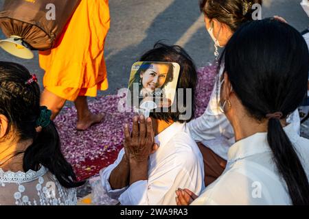 Bangkok, Thailand. Januar 2024. Ein Gläubiger versucht, während der Dhammayatra-Pilgerfahrt 2024 kühl zu bleiben. Die Dhammayatra-Pilgerfahrt 2024 fand am 2. Januar 2024 im Wat Dhammakaya in der Nähe von Bangkok statt, in Hommage an den Großen Meister Sodh Cantasaro, Schöpfer der Dhammakaya-Meditationstechnik, die heute weltweit Anhänger hat. Quelle: SOPA Images Limited/Alamy Live News Stockfoto