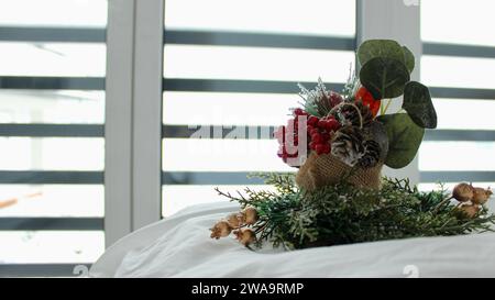 Dekorative Komposition auf einem schneeweißen Bett vor dem Hintergrund eines Fensters Stockfoto