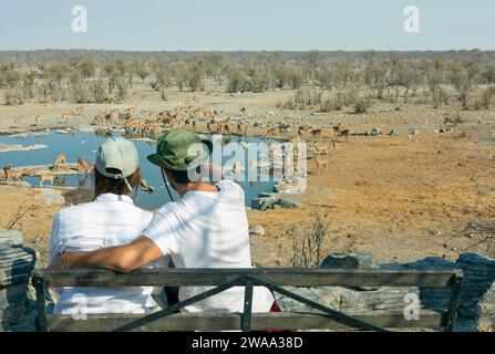 Rückansicht junger Tierbeobachtungspaare in der afrikanischen Savanne - Reisekonzept Stockfoto