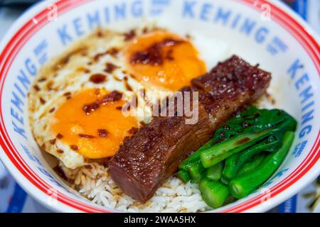 Köstlicher gegrillter Schweinefleisch-Reis mit zwei Eiern im Hong Kong-Teerestaurant Stockfoto