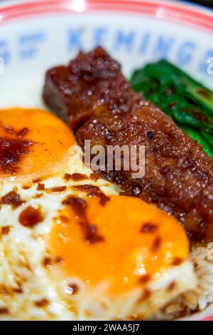 Köstlicher gegrillter Schweinefleisch-Reis mit zwei Eiern im Hong Kong-Teerestaurant Stockfoto