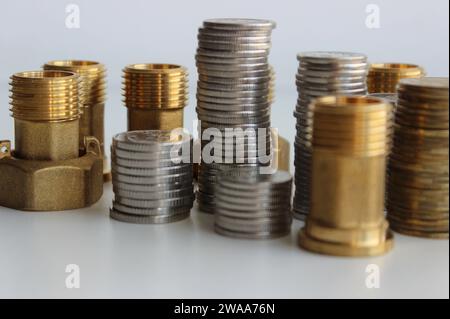 Shop Für Sanitär- Und Sanitär-Zubehör. Armaturen Und Verbindungsmuttern In Der Nähe Von Säulen Von Münzen Isoliertes Stockfoto Stockfoto