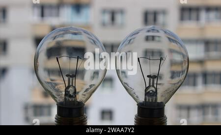 Zwei elektrische Licht Lampe mit mehrstöckigem Appartementhaus auf Einem Hintergrund als Illustration von Strom effizient Stockfoto