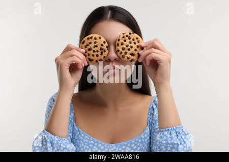 Junge Frau mit Schokoladenkeksen auf weißem Hintergrund Stockfoto