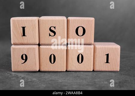 Internationale Organisation für Normung. Würfel mit der Abkürzung ISO 9001 auf einem grauen texturierten Tisch Stockfoto