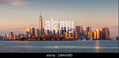 New York City Lower Manhattan Wolkenkratzer bei Sonnenuntergang. Panoramablick vom New Yorker Hafen mit dem World Trade Center und den Gebäuden des Finanzviertels Stockfoto