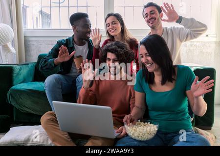 Freundschaft, Freizeit und Menschenkonzept – multiethnische Freunde mit Tablet-pc, die Videoanrufe führen und zu Hause trinken und essen Stockfoto