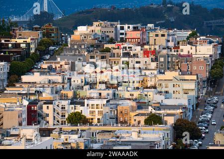 Farbenfrohe Häuser von San Francisco, die nach einem Regensturm im Frühjahr den Hügel hinaufkrabbeln, USA. Dunkle Wolken im Hintergrund. Stockfoto