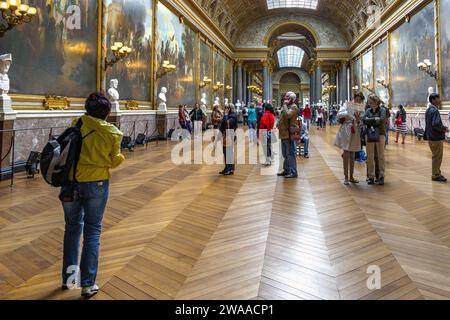 VERSAILLES, PARIS - 12. MAI 2013: Nicht identifizierte Besucher untersuchen Gemälde in der Galerie der Schlachten im Schloss Versailles. Stockfoto