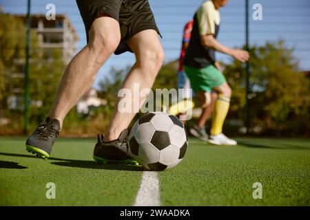 Fußballspieler, der den Ball abschneidet, Amateur-Football-Match Stockfoto