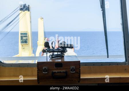 Nautischer schwarzer Sextant auf Holzkiste in der Navigationsbrücke. Navigationsausrüstung. Himmlische Navigation. Stockfoto