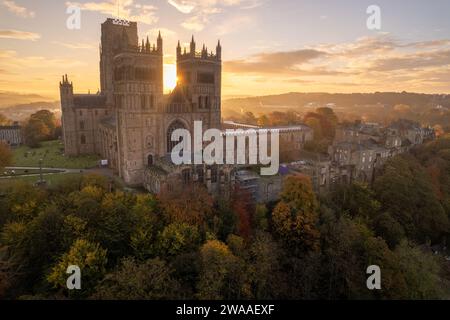 An einem atemberaubenden Herbstmorgen geht die Sonne zwischen den beiden Türmen der Kathedrale von Durham auf. Drohnenaufnahme Stockfoto