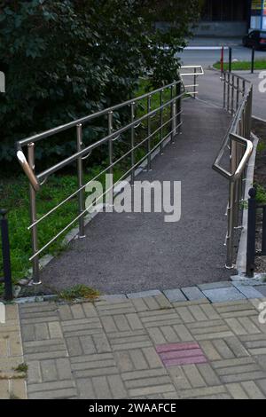 Glänzende Metallrampe für Behinderte. Ein spezieller Pfad für deaktivierte. Stockfoto