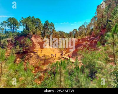 Ocker Trail in Roussillon in der Provence, Frankreich. Leuchtende und lebhafte Farben entlang des von den Bäumen verborgenen Pfades, wo er in einem amerikanischen Canyon zu sein scheint Stockfoto