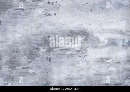 Schleifen Sie schäbige Betonwand mit gewaschener und verwitterter weißer Farbe bei Tageslicht, während Sie Kratzer auf der Zementkonstruktion mit grauem Hintergrund zeigen Stockfoto