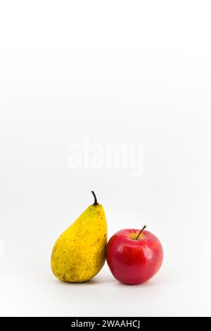 Ein lebendiges Bild mit einer gelben Birne und einem roten Apfel auf einem makellos weißen Hintergrund. Die kontrastierenden Farben schaffen eine optisch ansprechende Komposition Stockfoto