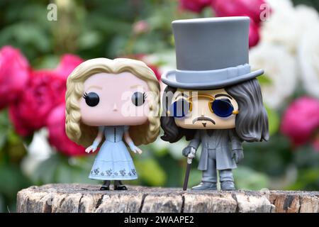 Funko Pop Actionfiguren von Alice im Wunderland aus Tim Burton Fantasy-Film und Bram Stokers Dracula Vampirprinz Vlad. Rote und weiße Rosen. Stockfoto