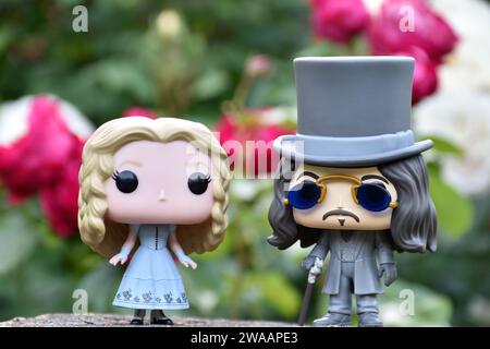 Funko Pop Actionfiguren von Alice im Wunderland aus Tim Burton Fantasy-Film und Bram Stokers Dracula Vampirprinz Vlad. Rote und weiße Rosen. Stockfoto