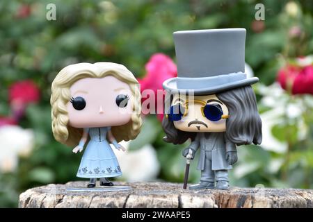 Funko Pop Actionfiguren von Alice im Wunderland aus Tim Burton Fantasy-Film und Bram Stokers Dracula Vampirprinz Vlad. Rote und weiße Rosen. Stockfoto