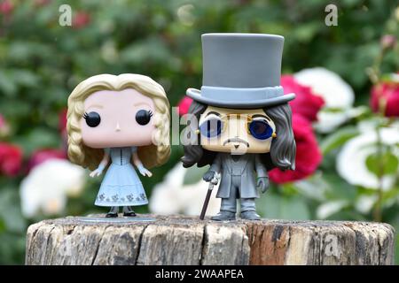 Funko Pop Actionfiguren von Alice im Wunderland aus Tim Burton Fantasy-Film und Bram Stokers Dracula Vampirprinz Vlad. Rote und weiße Rosen. Stockfoto