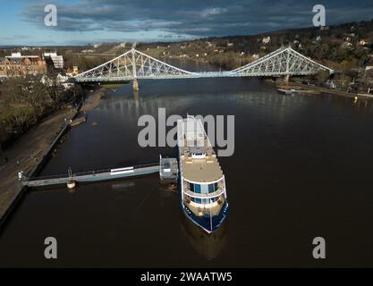 Dresden, Deutschland. Januar 2024. Das Salonschiff Gräfin Cosel von der Sächsischen Dampfschifffahrt liegt am Pier in Blasewitz an der Elbe vor der Brücke Blaues Wunder in Loschwitz. Die Weiße Flotte Sachsen wird in der ersten Januarwoche mit dem Umbau des ersten ihrer beiden Motorschiffe beginnen. Das renovierte Schiff soll am 1. Mai 2024 wieder zur Eröffnung der Hauptsaison mit der traditionellen Flottenparade fahren. (Luftaufnahme mit Drohne) Credit: Robert Michael/dpa/ZB/dpa/Alamy Live News Stockfoto