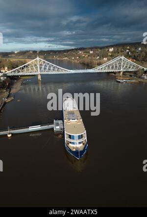 Dresden, Deutschland. Januar 2024. Das Salonschiff Gräfin Cosel von der Sächsischen Dampfschifffahrt liegt am Pier in Blasewitz an der Elbe vor der Brücke Blaues Wunder in Loschwitz. Die Weiße Flotte Sachsen wird in der ersten Januarwoche mit dem Umbau des ersten ihrer beiden Motorschiffe beginnen. Das renovierte Schiff soll am 1. Mai 2024 wieder zur Eröffnung der Hauptsaison mit der traditionellen Flottenparade fahren. (Luftaufnahme mit Drohne) Credit: Robert Michael/dpa/Alamy Live News Stockfoto