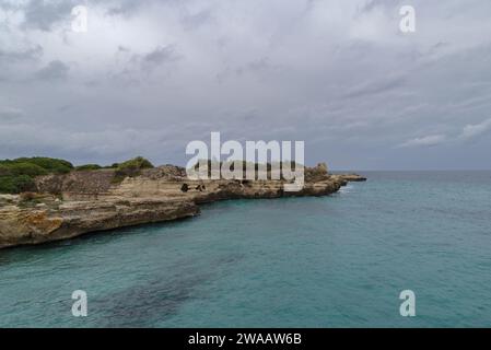 Poetry Cave (Grotta della Poesia) Naturpool umgeben von zerklüfteten Kalksteinklippen mit Höhlen und einem Tunnel zum offenen Meer. Apulien, Italien Stockfoto