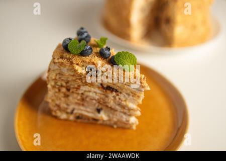 Hausgemachte Kuchen Napoleon, Millefeuille. Delikater Pudding-Kuchen, garniert mit Beeren und Minze. Auf einem grauen Betonstein Hintergrund. Stockfoto