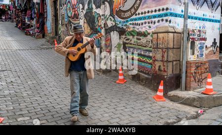 Cusco, Peru - 24. Oktober 2023: Ein peruanischer Mann, der Gitarre spielt und singt, auf der Straße der Stadt spaziert Stockfoto