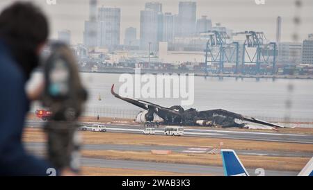 Tokio, Japan. Januar 2024. Beamte untersuchen ein verbranntes Flugzeug der Japan Airlines (JAL) Airbus A350 nach einer Kollision mit einem Flugzeug der japanischen Küstenwache MA722 Mizunagi (Bombardier DHC-8-300) am Flughafen Tokio (Haneda Airport) in Tokio, Japan am Mittwoch, 3. Januar 2024. Foto: Keizo Mori/UPI Credit: UPI/Alamy Live News Stockfoto