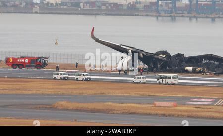 Tokio, Japan. Januar 2024. Beamte untersuchen ein verbranntes Flugzeug der Japan Airlines (JAL) Airbus A350 nach einer Kollision mit einem Flugzeug der japanischen Küstenwache MA722 Mizunagi (Bombardier DHC-8-300) am Flughafen Tokio (Haneda Airport) in Tokio, Japan am Mittwoch, 3. Januar 2024. Foto: Keizo Mori/UPI Credit: UPI/Alamy Live News Stockfoto