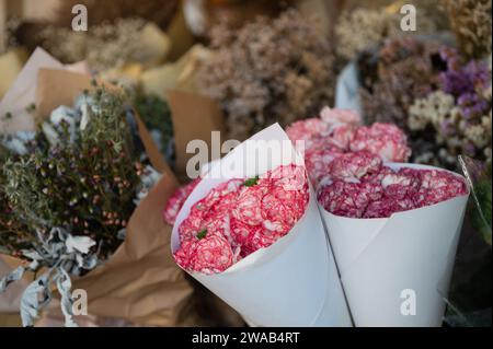 Wunderschöne rot-weiße Nelken in Papierverpackungen, die im Blumenladen verkauft werden Stockfoto