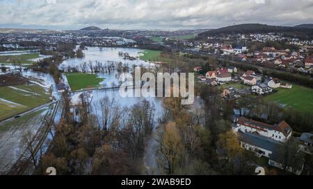 03. Januar 2024, Hessen, Fulda: Die stark aufgestiegene Fulda ist im Stadtteil Bronnzell über die angrenzenden Wiesen und das Sportgelände SG Viktoria Bronnzell geplatzt. Im Hintergrund ist die Stadt Fulda zu sehen. Nach den starken Regenfällen am Mittwoch und am Donnerstagabend platzen Flüsse und Bäche, darunter die Fulda, in Osthessen über die Ufer. An der Messstation im Fuldaer Stadtteil Bronnzell stieg das Niveau der Fulda sogar über die dritte Meldeebene, wo es nach Angaben des Landesamtes zu außergewöhnlichen Überschwemmungen kommt. (Foto mit einem d Stockfoto