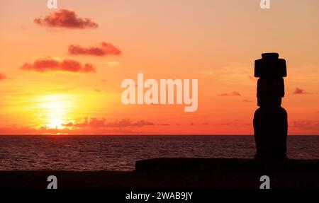 Silhouette von Moai mit Hut namens Pukao auf der Zeremonialplattform Ahu Ko Te Riku vor dem atemberaubenden Sonnenuntergangshimmel, Pazifik, Osterinsel, Chile Stockfoto